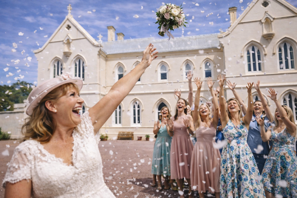 Bride and bridesmaids celebrating in front of a the Convent at Koroit with confetti.