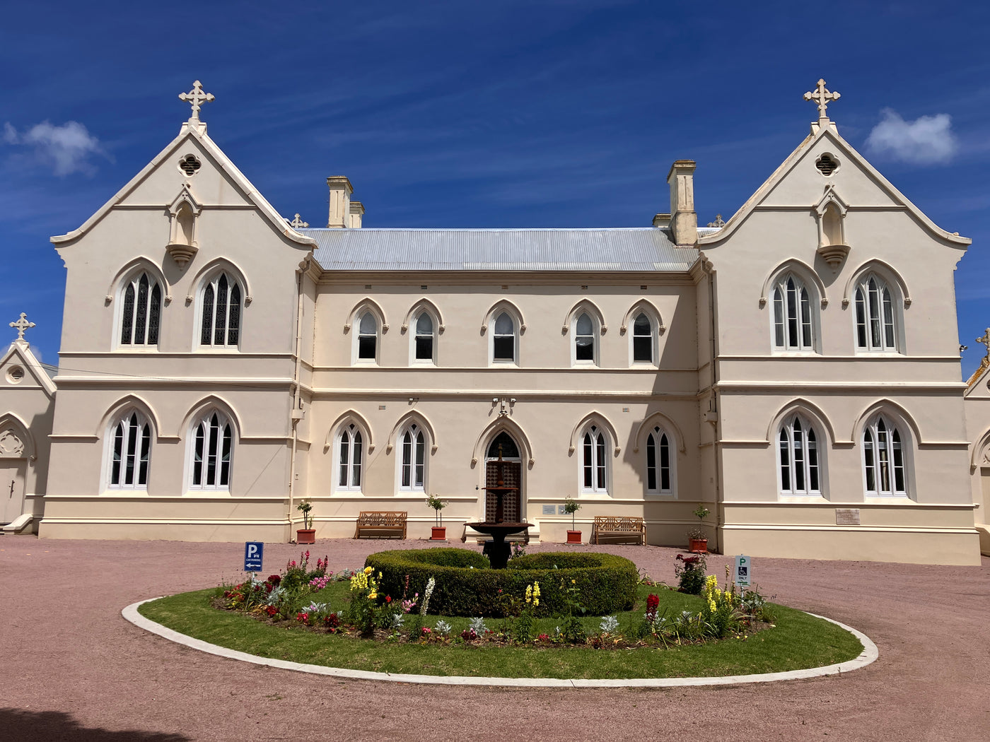 The Convent at Koroit looking at the front entrance and roundabout on a bright blue sky day.