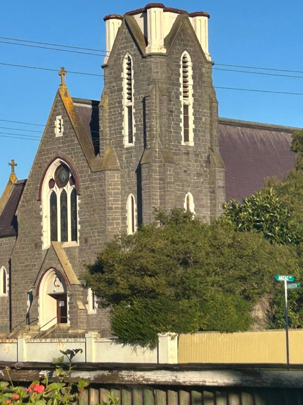 "The Magnificent Bluestone Catholic Church of the Infant Jesus, Koroit, Victoria established by Rev. James Parle in 1867. The stained glass windows feature intricate designs and vibrant colours, adding a rich historical and spiritual atmosphere to the church interior."