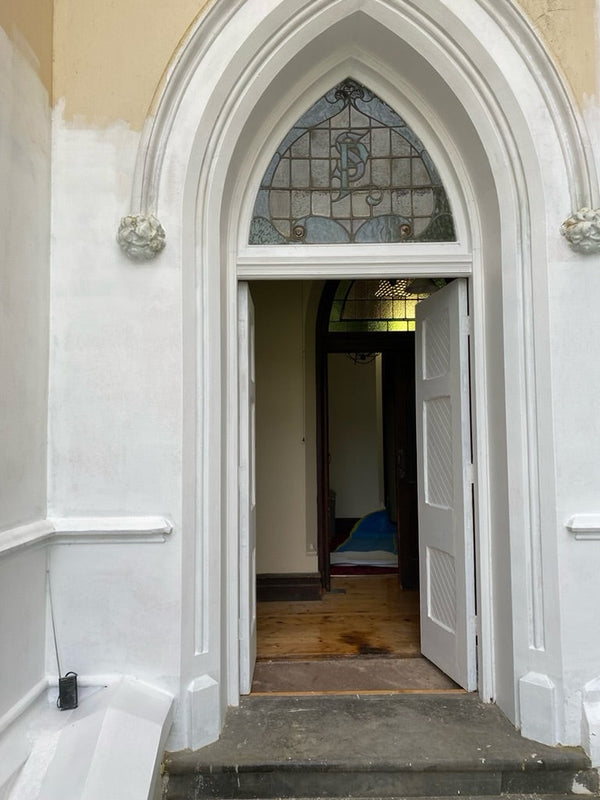 "Image of a partially restored door at The Convent at Koroit, highlighting the careful restoration process. The door features a blend of original woodwork and modern repairs, preserving its historical charm while enhancing its durability.