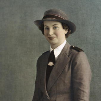 A vintage colorized portrait of a woman in an Australian military uniform with a matching hat, white shirt, dark tie, and brown gloves, posed against a textured gray background.