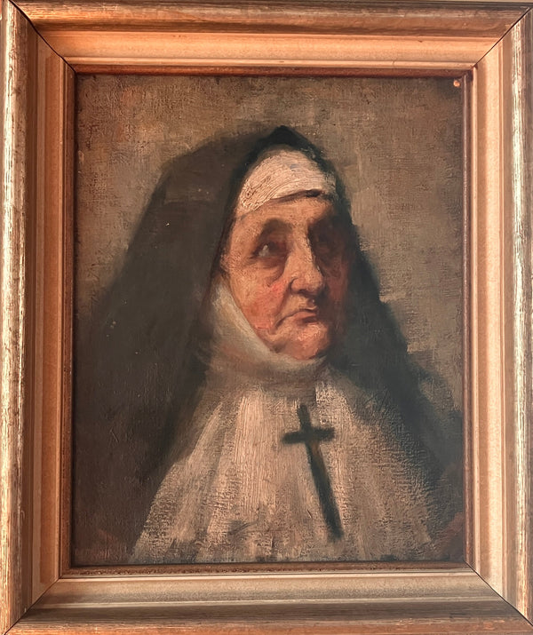 Portrait of a Nun with a headscarf and cross, framed in gold on a beige wall.