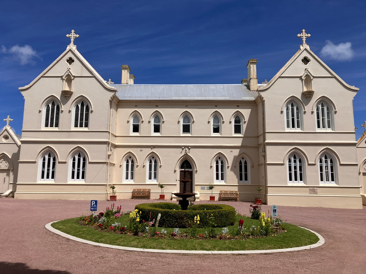 The Convent at Koroit looking at the front entrance and roundabout on a bright blue sky day.